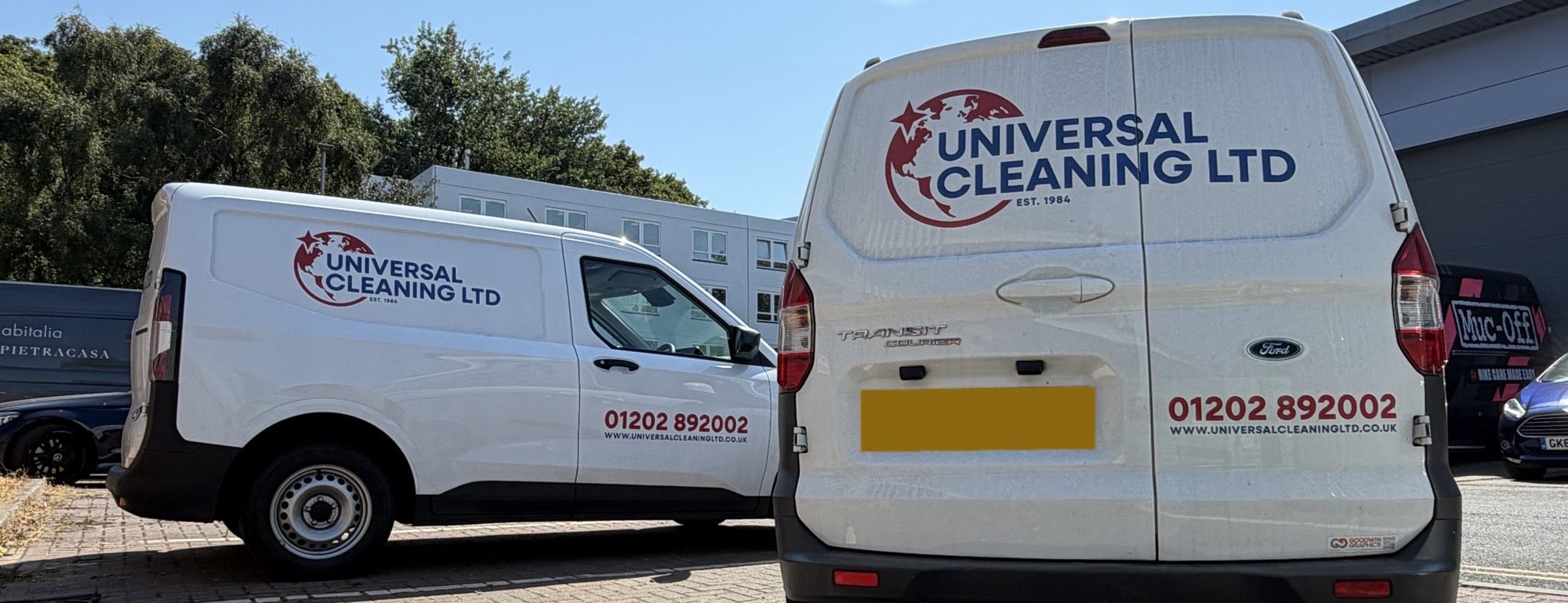 Two Universal Cleaning Ltd vans in the red and blue UCL livery, parked at the depot