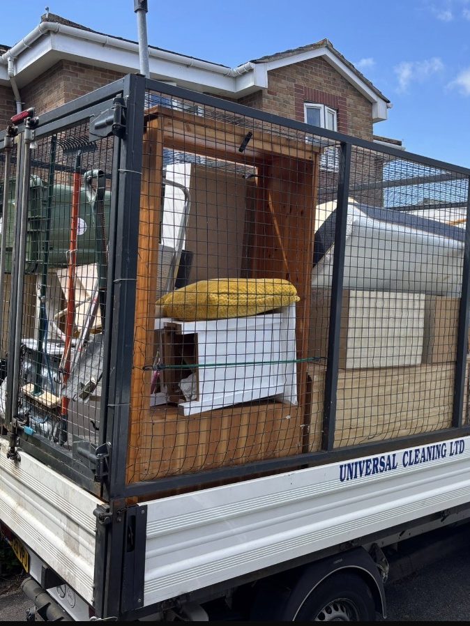 A Universal Cleaning caged tipper loaded with furniture on a property clearance